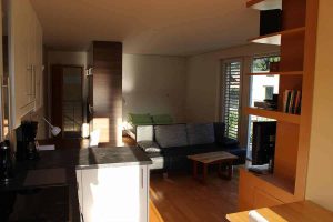 Helles Wohnzimmer mit moderner Einrichtung und Panoramafenster in einer Ferienwohnung Arlberg