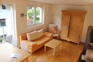 Helles Wohnzimmer mit moderner Einrichtung und Panoramafenster in Ferienwohnung Pettneu